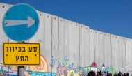 Israeli tourists take pictures of graffiti on part of Israeli barrier in the Israeli Kibbutz of Netiv Haashara along the border between Israel and the Gaza Strip on February 7, 2017 (AFP / Jack Guez) 
