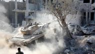 Syrian pro-government forces manoeuver a tank as they advance through Qabun district, on the outskirts of the capital Damascus, on May 13, 2017, during an offensive to retake the area from opposition fighters. / AFP / STRINGER
