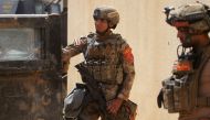 Members of the Iraqi Counter-Terrorism Service (CTS) take position as they advance towards Mosul's Al-Oraibi western district on May 14, 2017, during the ongoing offensive to retake the city from Islamic State (IS) group fighters. / AFP / AHMAD AL-RUBAYE