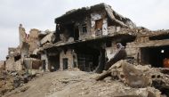FILE PHOTO: A Syrian man sits on the rubble of his house in Al-Arkoub neighbourhood of Aleppo on December 17, 2016 after pro-government forces retook the area from rebel fighters (AFP / Youssef KARWASHAN) 