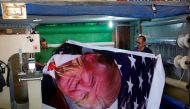 Palestinians print a poster depicting U.S. President Donald Trump in preparations for his planned visit, in the West Bank town of Bethlehem May 21, 2017. REUTERS/Mussa Qawasma
