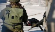 FILE PHOTO: A Palestinian woman lies on the ground after she was shot and wounded by Israeli security forces at Qalandia checkpoint between Jerusalem and the occupied West Bank on December 30, 2016 (AFP / Abbas Momani) 