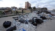 People walk near rubble inside Waer district, after rebel fighters and their families evacuated the besieged Waer district in the central Syrian city of Homs, after an agreement was reached between rebels and Syria's army, Syria May 21, 2017. REUTERS/Omar