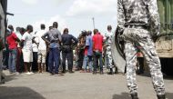Disgruntled former rebels demanding government compensation payments speak to gendaremes and police officers as they block a road on May 22, 2017 into Ivory Coast's second biggest city, Bouake. / AFP / STR.