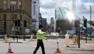 A police officer potrols a cordon near to the Manchester Arena in Manchester, northwest England on May 23, 2017 following a deadly terror attack at the Ariana Grande concert at the Manchester Arena the night before. AFP / Oli SCARFF
