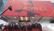 Cannes Film Festival general delegate Thierry Fremaux, Cannes Film festival president Pierre Lescure, actress Isabelle Huppert and staff members observe a minute of silence on the red carpet. REUTERS/Eric Gaillard
