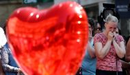 A woman reacts before a minute of silence for the victims of the Manchester Arena attack, in St Ann's Square, in central Manchester, Britain May 25, 2017. REUTERS/Stefan Wermuth
