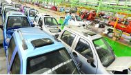 Employees push a newly-assembled electric car to be exported to South America along a production line at an electric vehicle factory in Zouping county, Shandong province of China. 