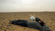 (FILES) This picture taken on October 8, 2005 shows a would-be immigrant resting in the middle of the Sahara Desert, near the border with Algeria. AFP PHOTO / SAMUEL ARANDA