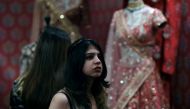 An Indian woman looks at different designer dresses at a stall during the Vogue Wedding Show 2016 in New Delhi on August 5, 2016 (AFP) 