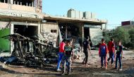 People walk at a site hit by an air strike in the rebel-held Tafas town, in Deraa Governorate, Syria, yesterday.