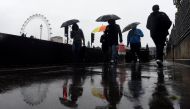 Commuters walk past security barriers on a wet and windy morning on Westminster Bridge, in London, Britain, June 6, 2017. REUTERS/Clodagh Kilcoyne.