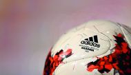The sign of the German sports goods company Adidas is seen at the mini version of the official match ball 