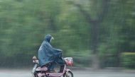 A woman rides an electric scooter in heavy rain in Fuyang, Anhui province, China June 10, 2017. (REUTERS)