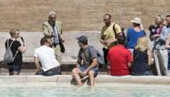 A tourist baths his feet in the Trevi Fountain in Rome on Monday