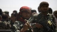 Members of the US-backed Syrian Democratic Forces (SDF) stand in the village of Hazima on the northern outskirts of the Islamic State (IS) group's Syrian bastion of Raqa on June 6, 2017 (AFP Photo/DELIL SOULEIMAN).