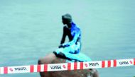Police tape is seen in front of a paint-covered Little Mermaid statue in Copenhagen, yesterday.