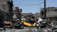 Damaged cars are seen stacked in the middle of a road in western Mosul's Zanjili neighbourhood on June 9, 2017, during ongoing battles to try to take the city from Islamic State (IS) group fighters. / AFP / MOHAMED EL-SHAHED