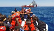 Migrants on a dinghy are rescued by 