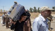 Displaced Iraqis arrive at a temporary camp in the compound of the closed Nineveh International Hotel in Mosul on June 16, 2017 which was recovered by Iraqi troops from Islamic State group fighters earlier in the year. (AFP / MOHAMED EL-SHAHED)