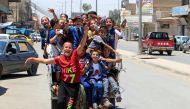 Iraqi children enjoy riding a mini car as they celebrate Eid al-Fitr, in Mosul, Iraq June 25, 2017. (REUTERS/Alaa Al-Marjani)