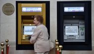 A woman uses a golden ATM, marking the location of the first 'hole in the wall,' which opened fifty years ago, in Enfield, Britain June 27, 2017. REUTERS/Hannah McKay
