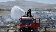 Civil defence members put out fire at a camp for Syrian refugees near the town of Qab Elias, in Lebanon's Bekaa Valley, July 2, 2017. (REUTERS/Hassan Abdallah)