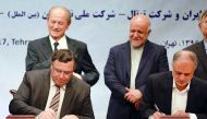 Iranian Oil Minister Bijan Namadar Zanganeh (C-R) looks on as Patrick Pouyanne (L), Chairman and CEO of French energy company Total, and Ezzatollah Akbari, Managing Director of Petropars Group, sign an offshore gas field agreement in Tehran, on July 3, 20