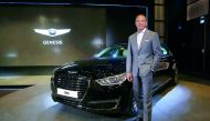 A senior official of the company poses for a photo with the Genesis G90.