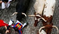 A runner falls in front of bulls during the fifth Running of the Bulls at the San Fermin festival in Pamplona, Spain July 11, 2017. REUTERS/Susana Vera.