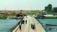 Iraqis cross a bridge connecting west and east Mosul, yesterday, a few days after the government's announcement of the 