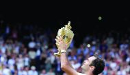 Switzerland’s Roger Federer poses with the trophy as he celebrates winning the men's singles final of the 2017 Wimbledon Championships against Croatia’s Marin Cilic at the All England Lawn Tennis Club in Wimbledon, southwest London yesterday. Federer won 