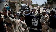 Members of the Iraqi Army's 9th Armoured Division are photographed with an Islamic State flag, claimed after fighting with Islamic State militants in western Mosul, Iraq June 17, 2017. (REUTERS/Alkis Konstantinidis/File Photo)
