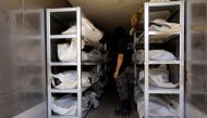 A member of Libyan anti-crime service stands next to dead bodies of Islamic State militants, at a morgue in Misrata, Libya July 22, 2017. Reuters/Ismail Zitouny