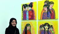 Qatari artist Lina Al Ali with her paintings on display at the “50X50” exhibition at Al Markhiya Gallery at Katara Art Centre. Pic: Kammutty V P / The Peninsula
