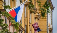 A Russian flag flies next to the US embassy building in Moscow on July 31, 2017. President Vladimir Putin on July 30, 2017 said the United States would have to cut 755 diplomatic staff in Russia and warned of a prolonged gridlock in its ties after the US 