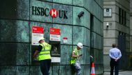 Customers use ATMs outside a branch of a HSBC bank in London, yesterday.