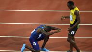 US athlete Justin Gatlin kneels in front of Jamaica's Usain Bolt after Gatlin won the final of the men's 100m athletics event at the 2017 IAAF World Championships at the London Stadium in London on August 5, 2017. (AFP / ANTONIN THUILLIER)