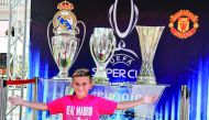 A child poses in front of trophies at the Super Cup fan zone in Skopje yesterday, one day ahead of Super Cup match between Real Madrid and Manchester United.