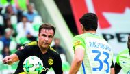 Dortmund’s midfielder Mario Goetze (left) and Wolfsburg’s forward Mario Gomez vie for the ball during their Bundesliga match  in Wolfsburg, western Germany yesterday. 