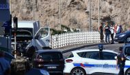 French forensic police officers and security personnel gather near a vehicle following a car crash in the southern Mediterranean city of Marseille on August 21, 2017. AFP / BERTRAND LANGLOIS
