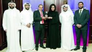 Roya Khajeh, Commercial Bank AGM, Head of Cards and Payments posing with the award with other officials.