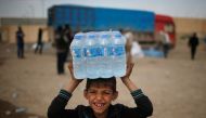 REPRESENTATIVE IMAGE: A displaced Iraqi boy smiles after receiving water in western Mosul, March 28, 2017 (Reuters/Suhaib Salem) 