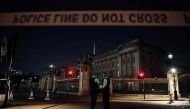 Police officers stand guard at a police cordon next to Buckingham Palace following an incident where a man armed with a knife was arrested outside the palace following a disturbance in London on August 26, 2017. / AFP.