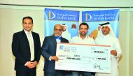 Dr R Seetharaman (second left), CEO of Doha Bank, handing over the QR1m prize ceremonial cheque to Xavier ‘Xavi’ Hernandez Creus (second right), the winner of this year’s third Al Dana draw, at Doha Bank’s Mall of Qatar branch.