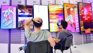 Two men sit in front of television screens on display at the booth of Vestel as preparations are under way for the consumer electronics fair IFA in Berlin on August 30, 2017. The fair is open for the public from September 1 to 6, 2017.  AFP / Tobias Schwa