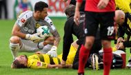 Dortmund's Swiss goalkeeper Roman Buerki kneels next to injured teammate defender Marcel Schmelzer during the German first division Bundesliga football match SC Freiburg vs Borussia Dortmund in Freiburg, southwestern Germany, on September 9, 2017.  AFP / 
