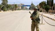 A picture taken during a press tour provided by the Russian Armed Forces on September 15, 2017 shows a Russian soldier standing guard in a central street in Syria's eastern city of Deir Ezzor. / AFP / Dominique DERDA