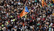 People holding 'Esteladas' (Catalan pro-independence flags) attend a protest near the Economy headquarters of Catalonia's regional government in Barcelona on September 20, 2017.   AFP / PAU BARRENA