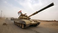 An Iraqi soldier waves his hat from the turret of a Russian-made T-72 tank, as Iraqi forces advance towards the city of al-Sharqat on September 20, 2017, where Iraqi forces backed by Hashed al-Shaabi (Popular Mobilisation) paramilitaries are preparing to 